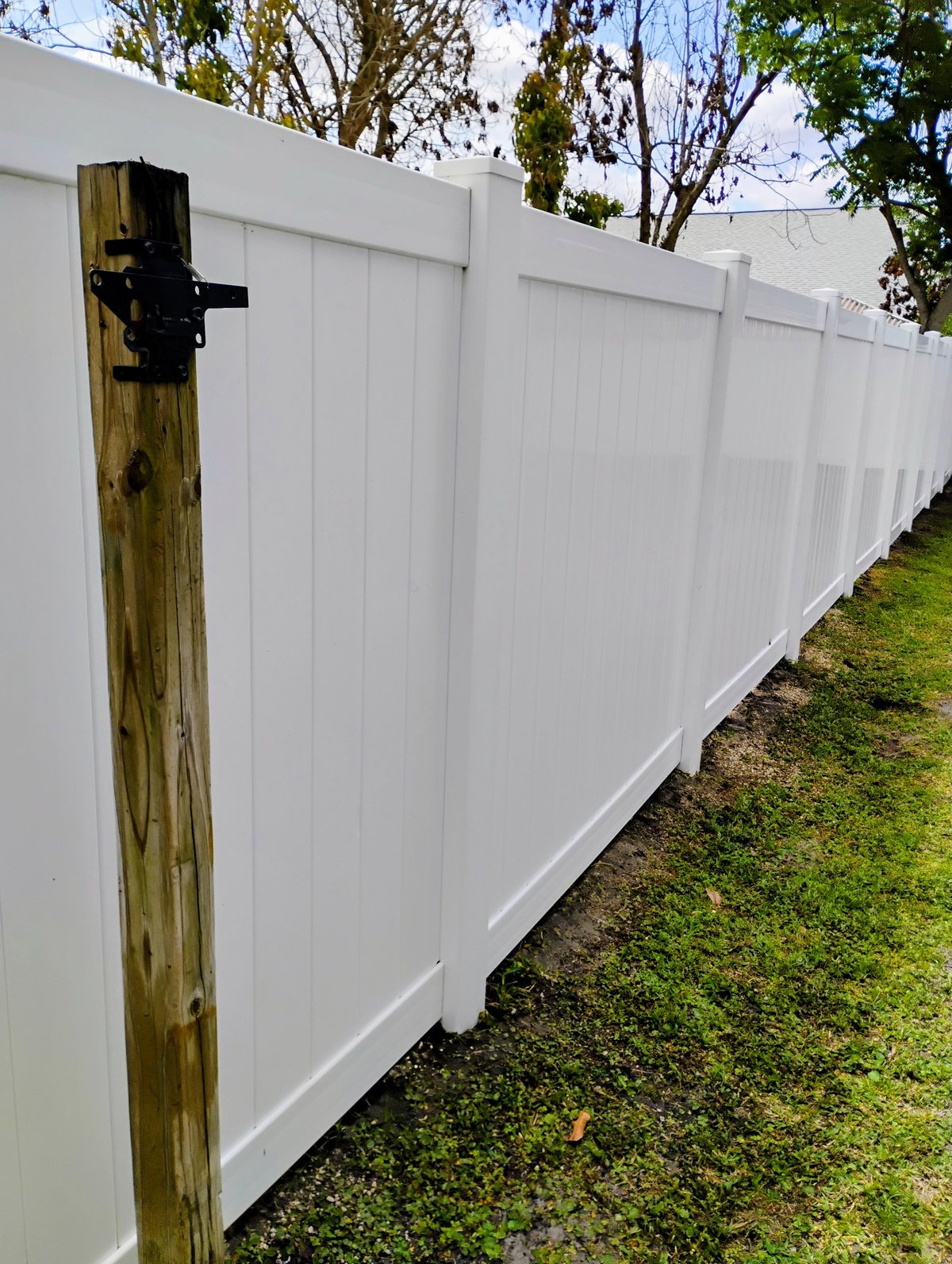 Clean white vinyl privacy fence after professional pressure washing - Orlando FL